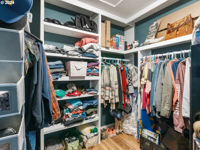 a view of walk in closet with clothes and shoes