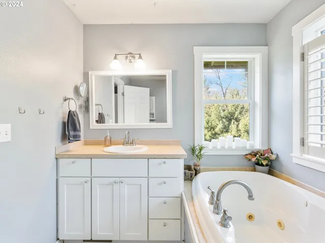 a bathroom with a bathtub a sink and a window