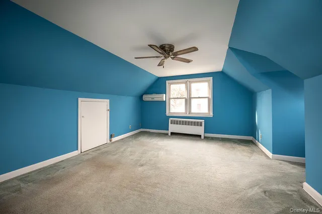 an empty room with windows and ceiling fan