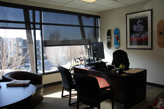 a view of a workspace with furniture and a window