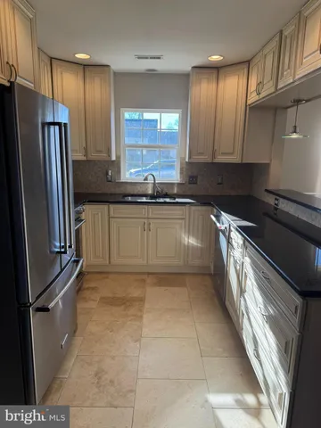 a kitchen with stainless steel appliances granite countertop a refrigerator and a sink
