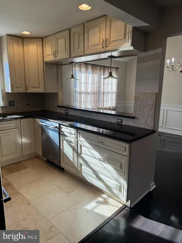 a kitchen with kitchen island granite countertop a sink cabinets and stainless steel appliances