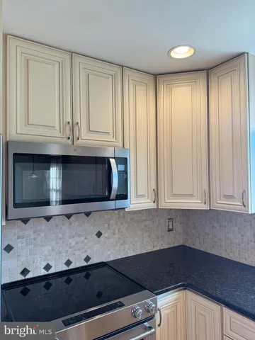 a kitchen with granite countertop cabinets stainless steel appliances and a counter space