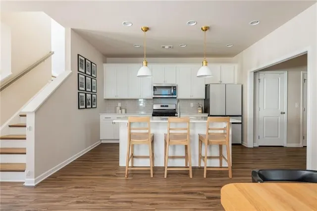 a kitchen with stainless steel appliances a sink stove and cabinets