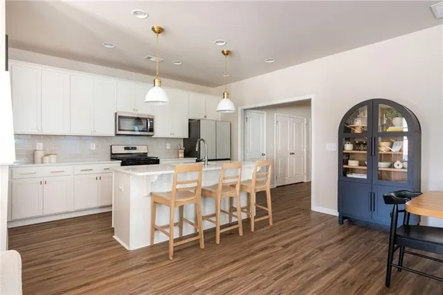 a open kitchen with a sink a table and chairs
