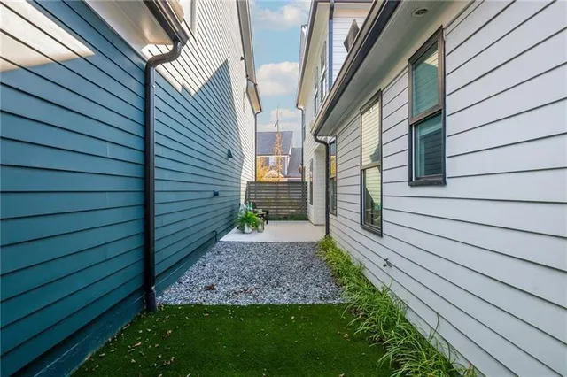 a view of a patio with dining table and chairs with a small yard and plants