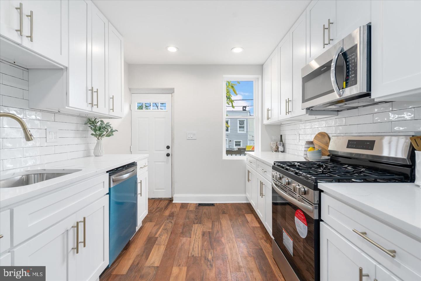 223 North Milton Avenue Baltimore, MD 21224 - Photo 2 of 14 a kitchen with stainless steel appliances granite countertop a stove and a sink