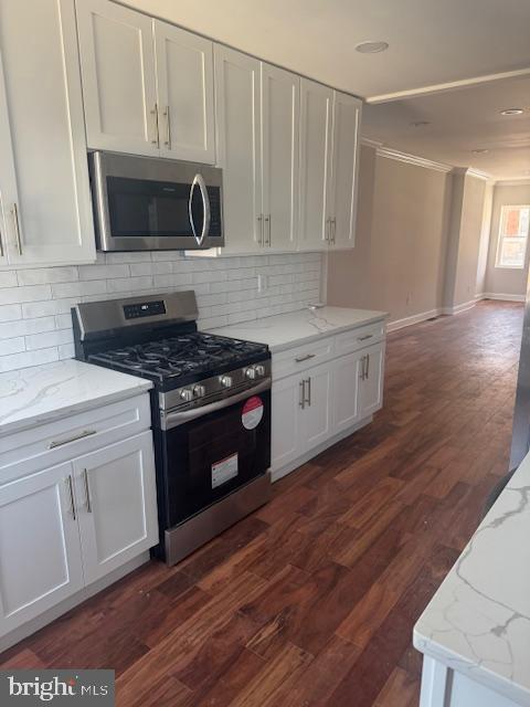 223 North Milton Avenue Baltimore, MD 21224 - Photo 3 of 14 a kitchen with granite countertop a stove a microwave a sink and cabinets