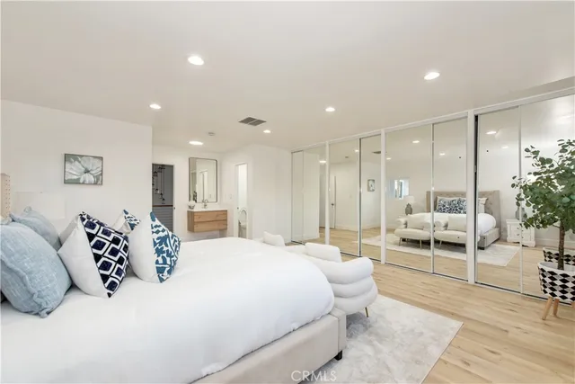 a bedroom with a large bed and a view of living room