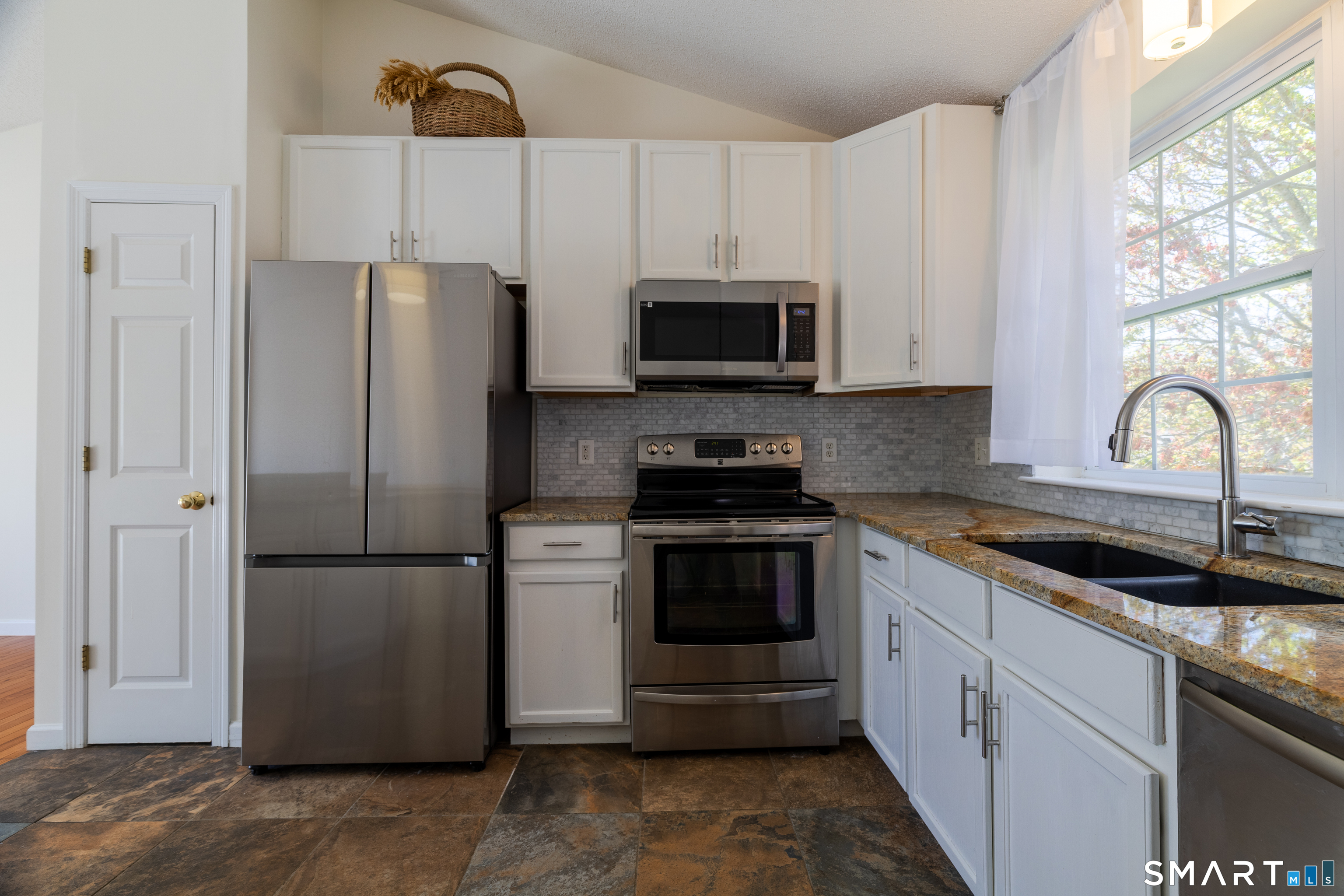 226 Noank Ledyard Road Groton, CT 06355 - Photo 4 of 26 a kitchen with refrigerator a microwave a sink and cabinets
