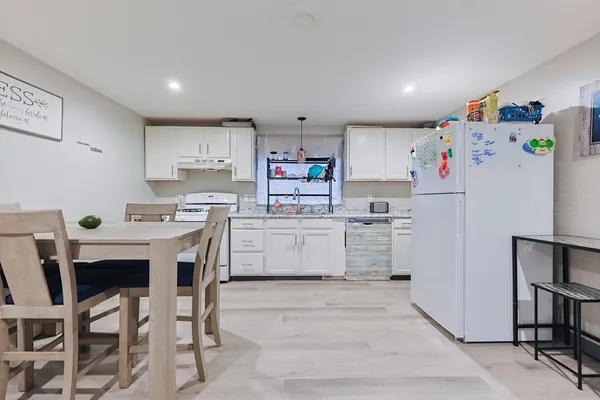 a kitchen with white cabinets and stainless steel appliances