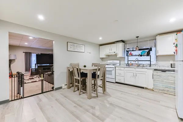 a white kitchen with sink and wooden floor