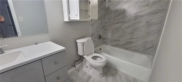 a white toilet sitting next to a bath tub