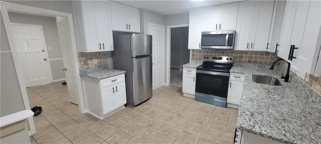 a kitchen with stainless steel appliances granite countertop a refrigerator stove and sink