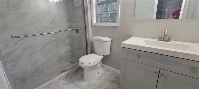 a white toilet sitting next to a bathroom sink
