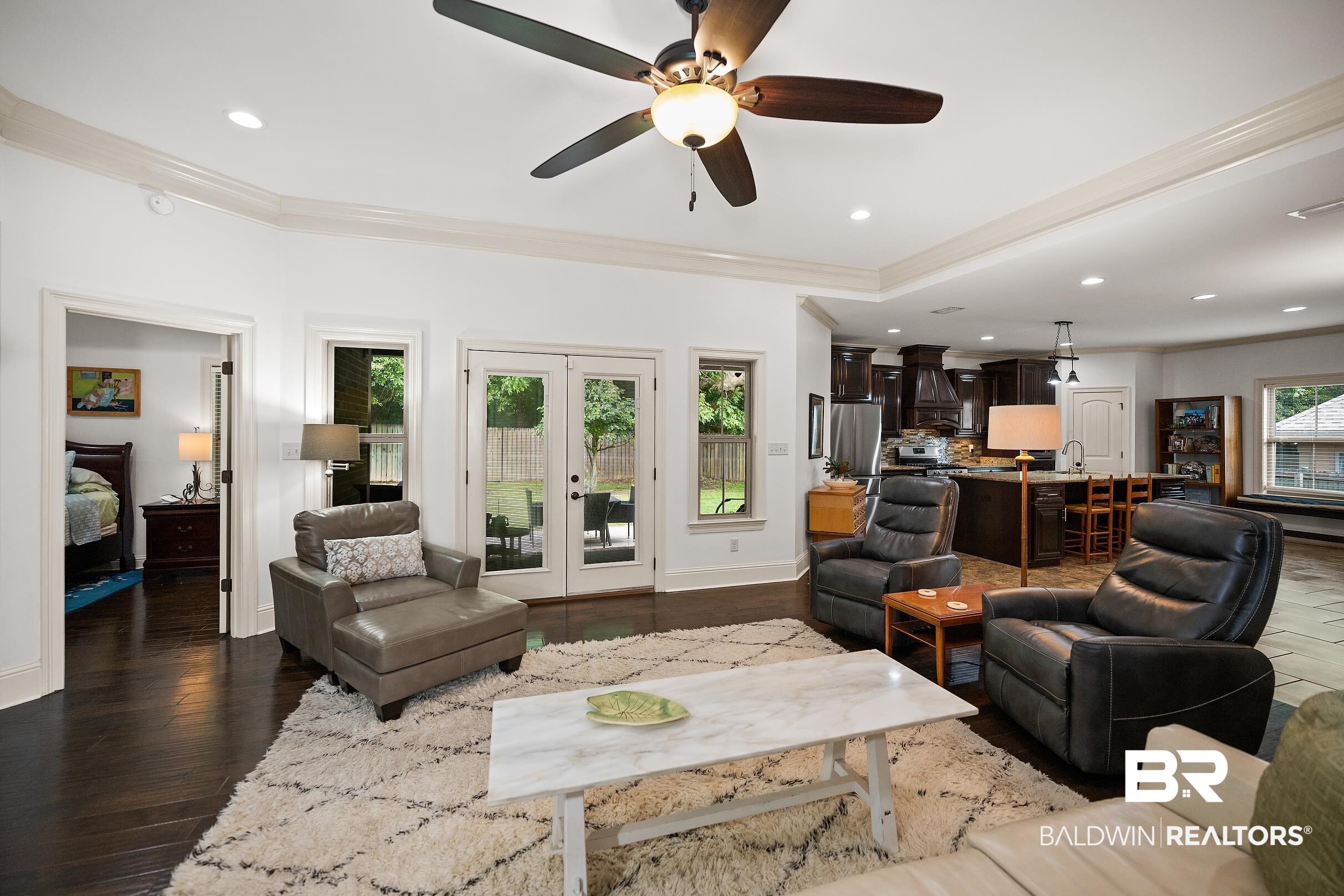 313 Pecan Ridge Boulevard Fairhope, AL 36532 - Photo 11 of 51 Open-concept living area featuring dark wood-finish flooring, white tray ceiling with crown molding, and recessed lighting