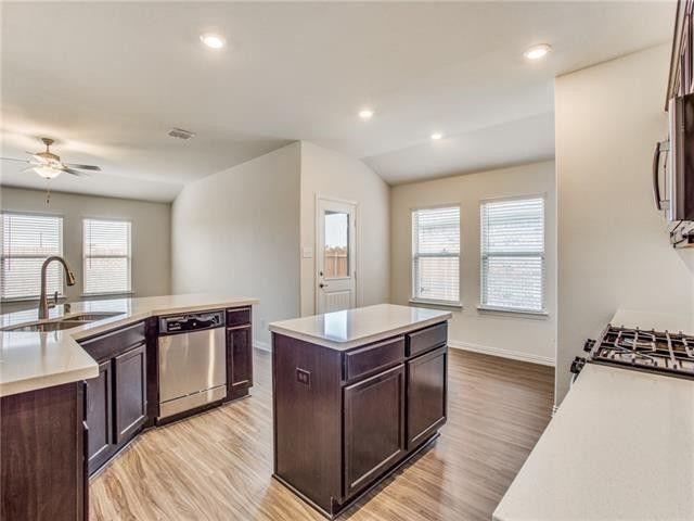 504 Brook View Court Anna, TX 75409 - Photo 5 of 10 a kitchen with stainless steel appliances granite countertop a sink stove and wooden cabinets