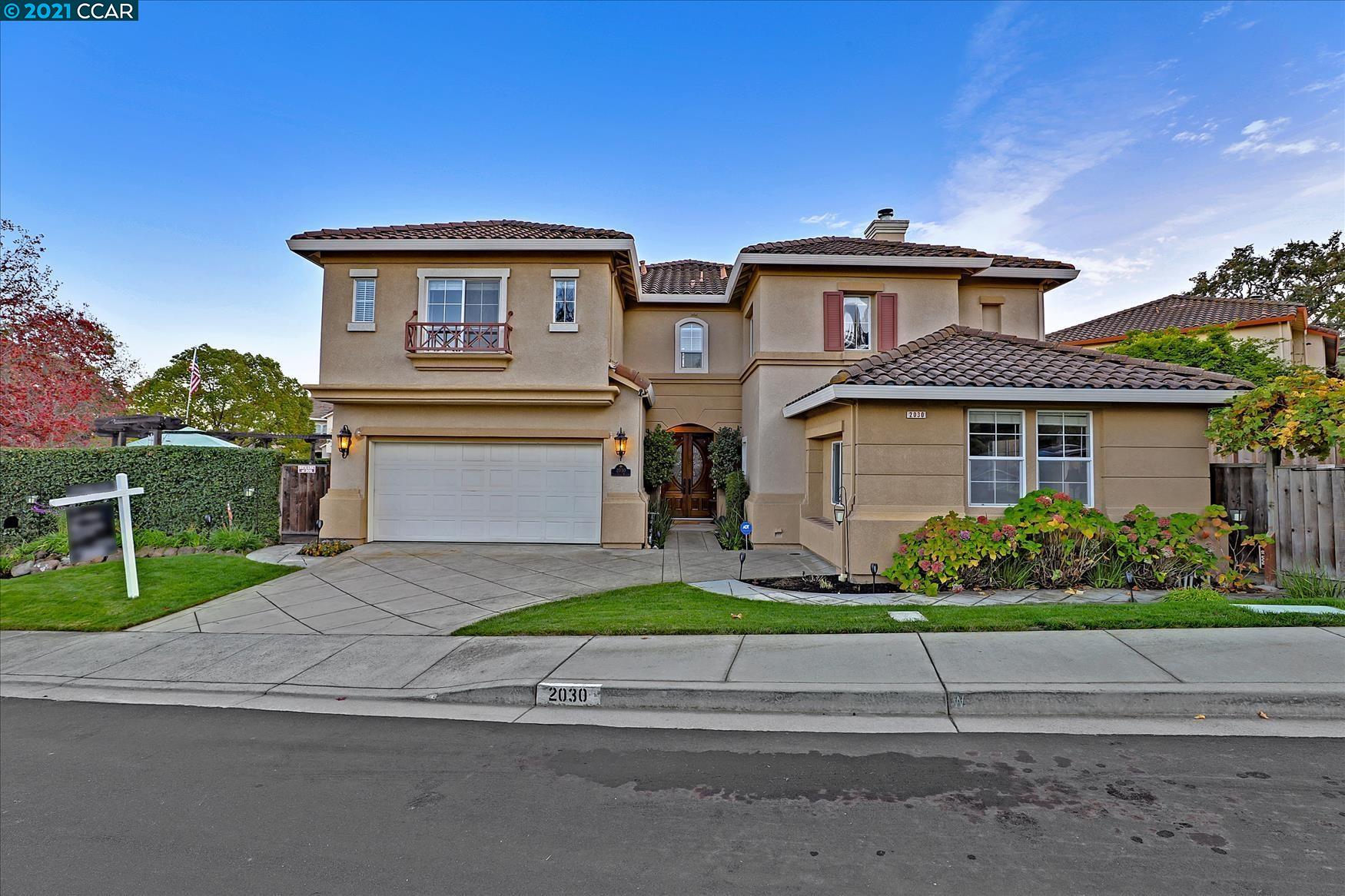 a front view of a house with a garden and plants