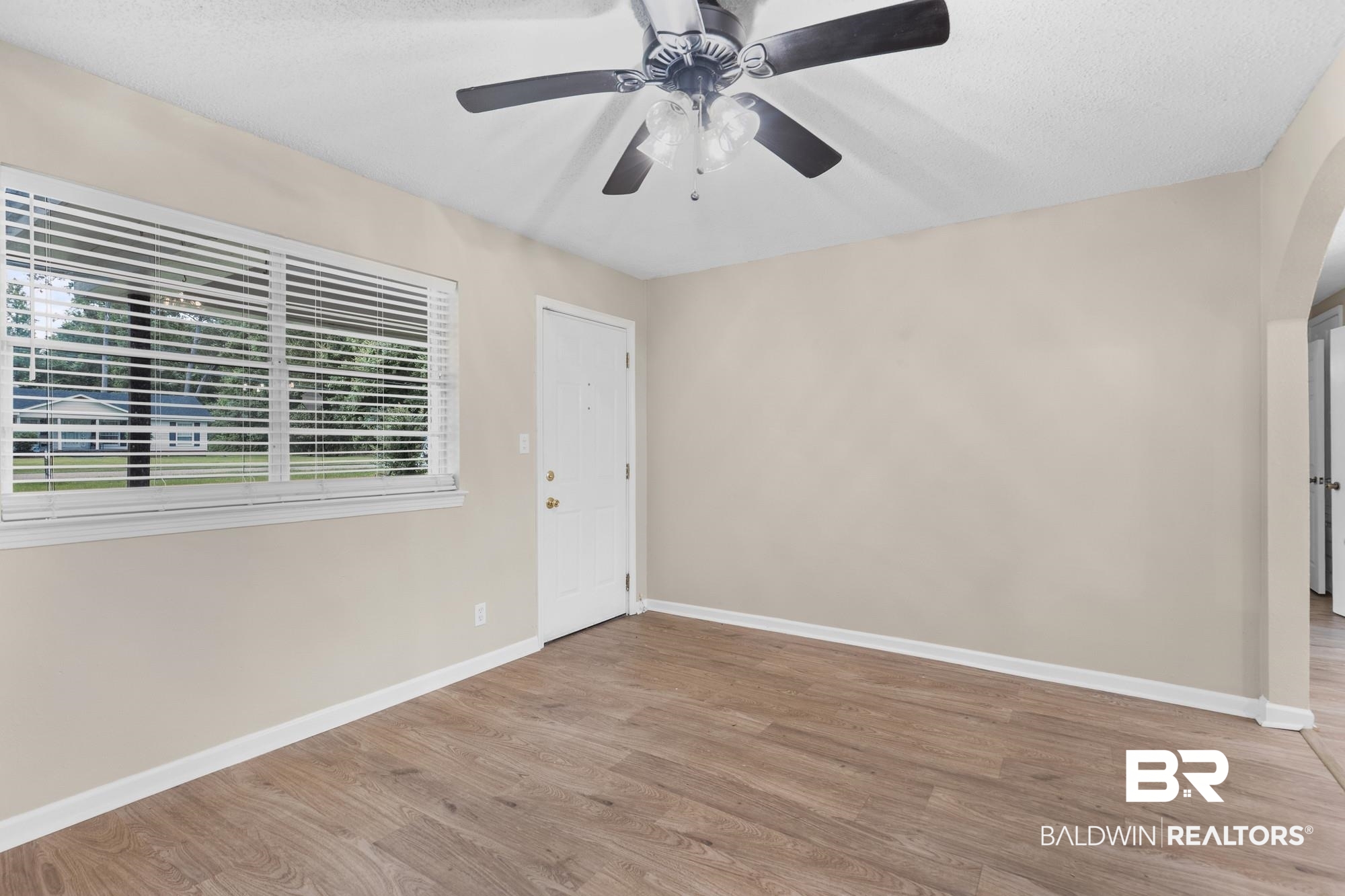 1560 Military Road Mount Vernon, AL 36560 - Photo 12 of 26 Unfurnished room featuring wood-finish flooring, a ceiling fan with light, and neutral wall tones