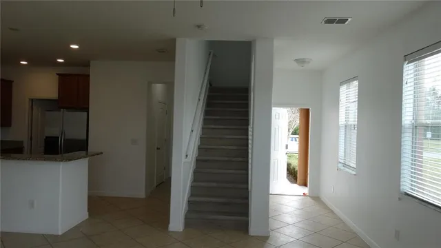 a view of a livingroom with a chandelier fan and windows