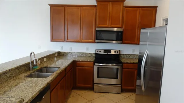 a kitchen with stainless steel appliances granite countertop a sink stove and microwave