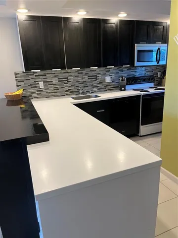 a view of a hallway and a stove in a kitchen