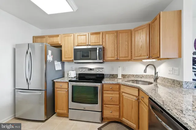 a kitchen with stainless steel appliances granite countertop a refrigerator stove a sink and dishwasher