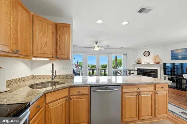 a kitchen with granite countertop a sink stove and cabinets