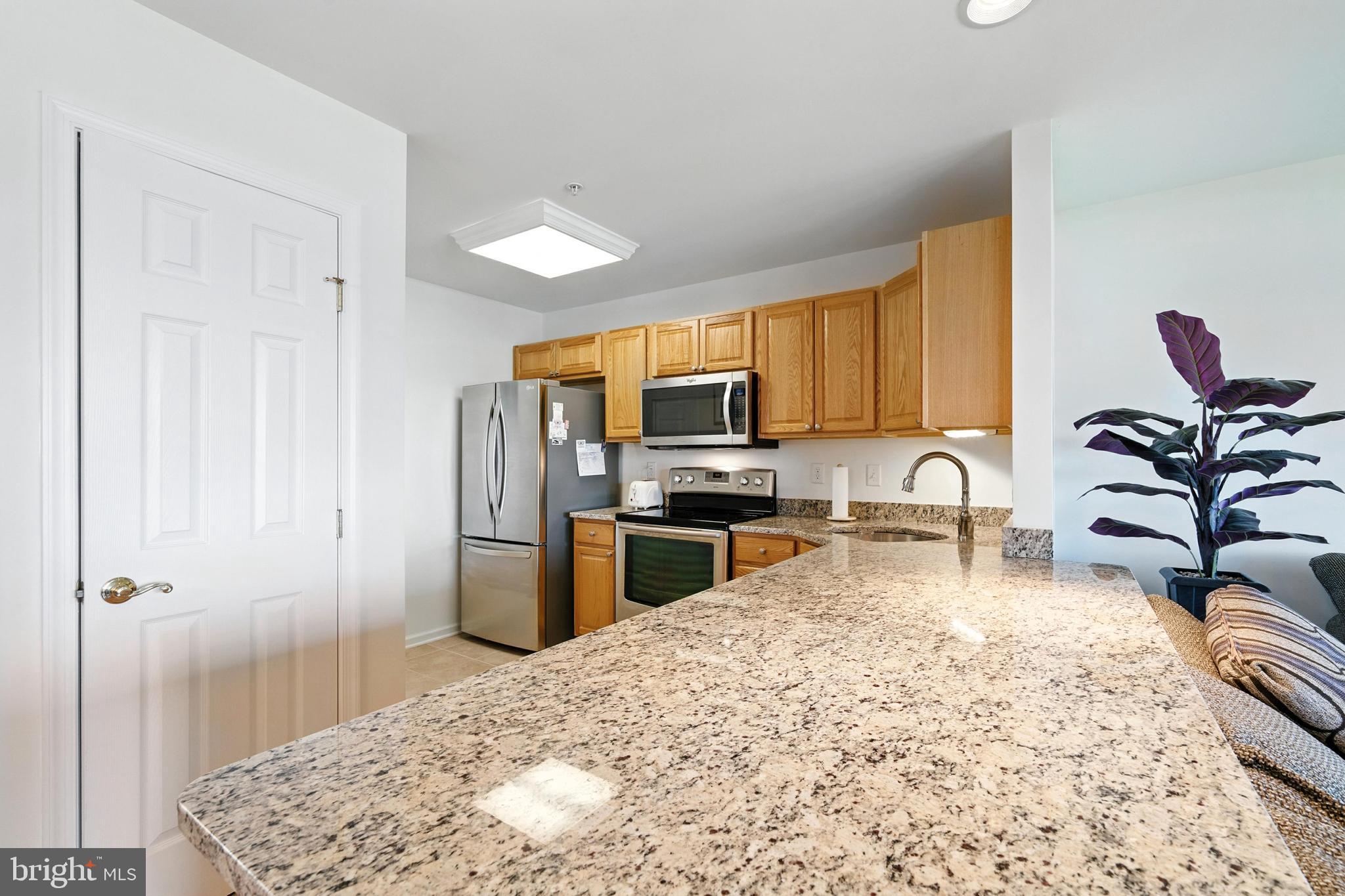 21090 West Sharp Street, Unit 133 Rock Hall, MD 21661 - Photo 10 of 40 a kitchen with a refrigerator sink and cabinets