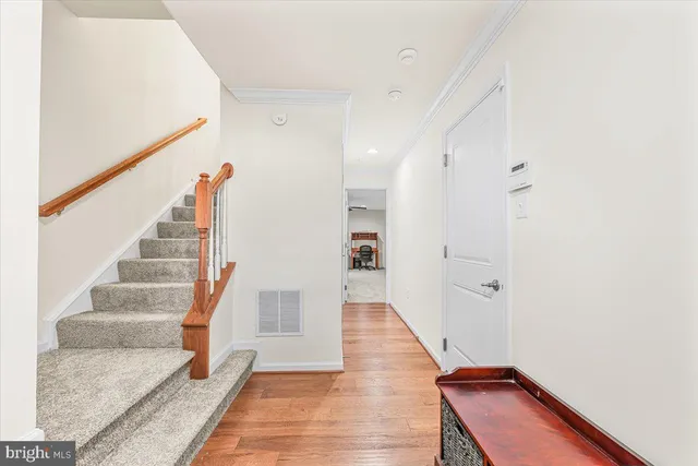 a view of a hallway with wooden floor and staircase