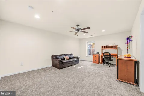 a living room with furniture and a ceiling fan
