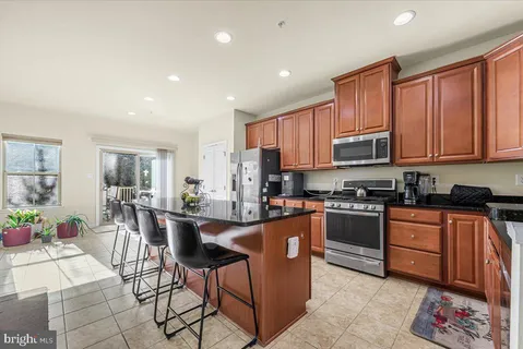a kitchen with kitchen island granite countertop lots of counter top space and stainless steel appliances