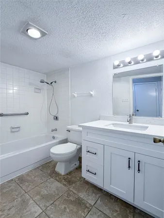 a bathroom with a granite countertop toilet a sink and a bathtub
