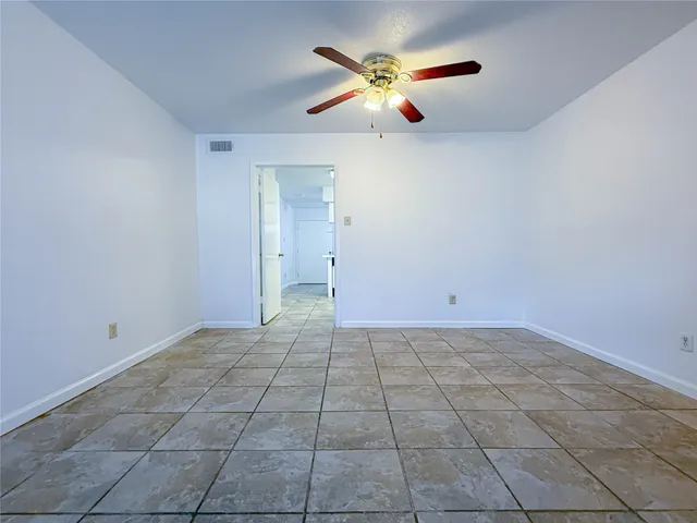 an empty room with closet and fan