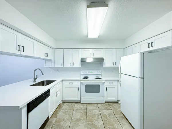 a kitchen with a sink a refrigerator and cabinets