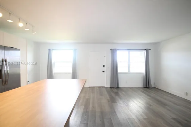 a view of a livingroom with wooden floor and a window