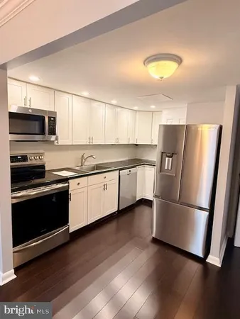 a bedroom with a bed and a lamp on dresser