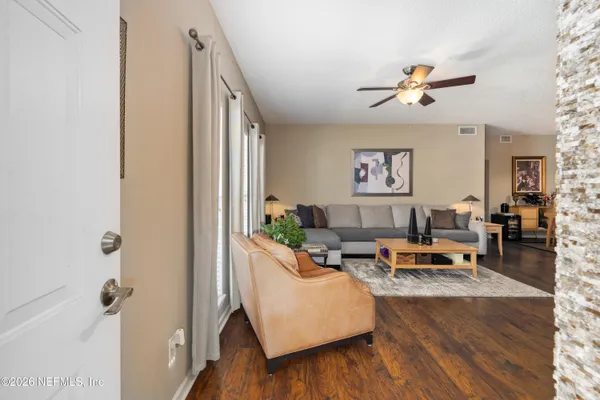 a living room with furniture and wooden floor