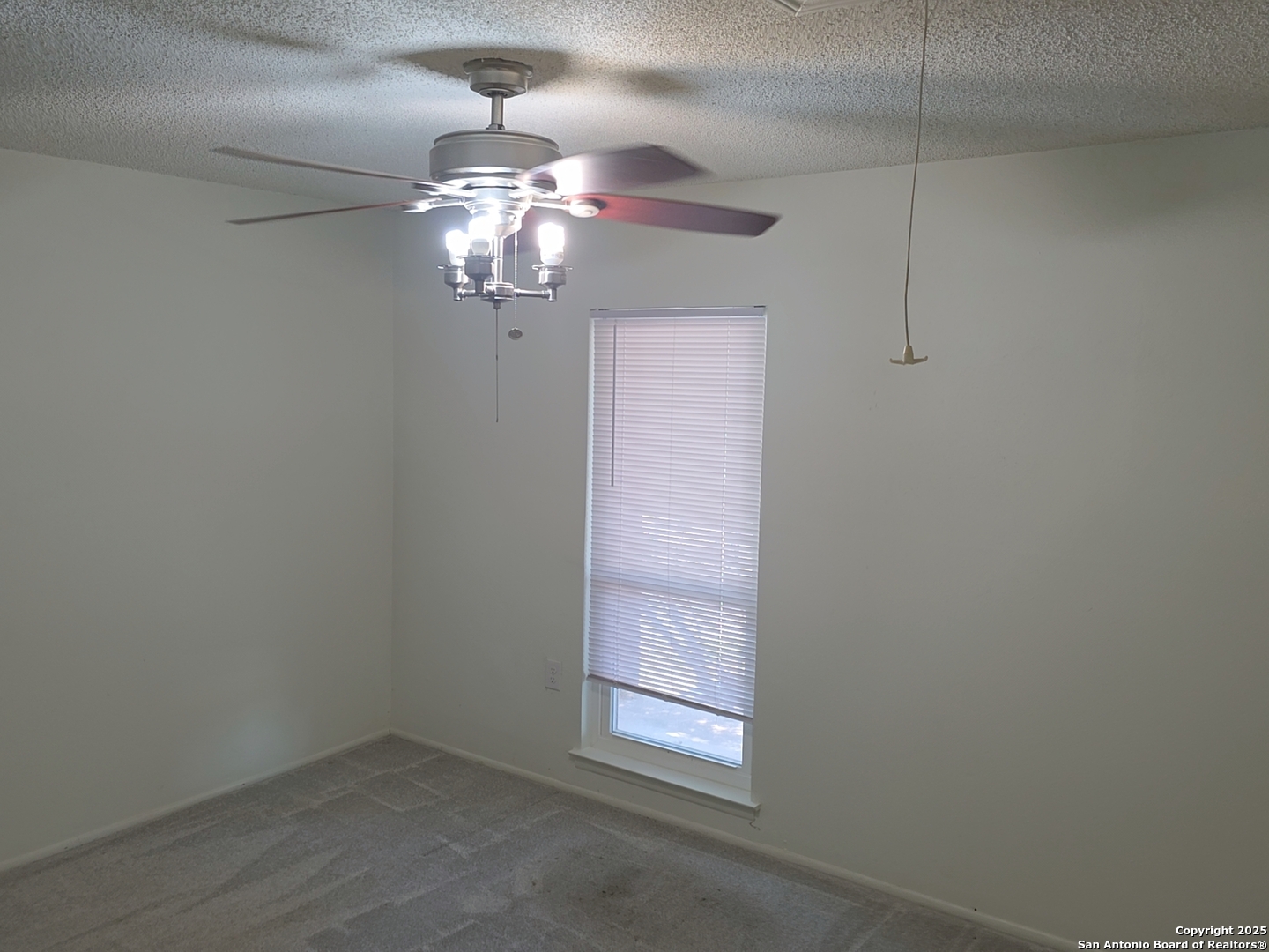 13339 Los Indios San Antonio, TX 78233 - Photo 10 of 17 en empty room with a chandelier fan and wooden floor