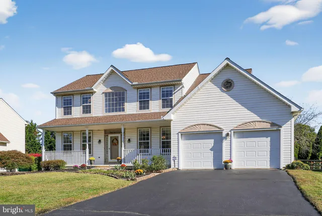 a front view of a house with a yard and potted plants