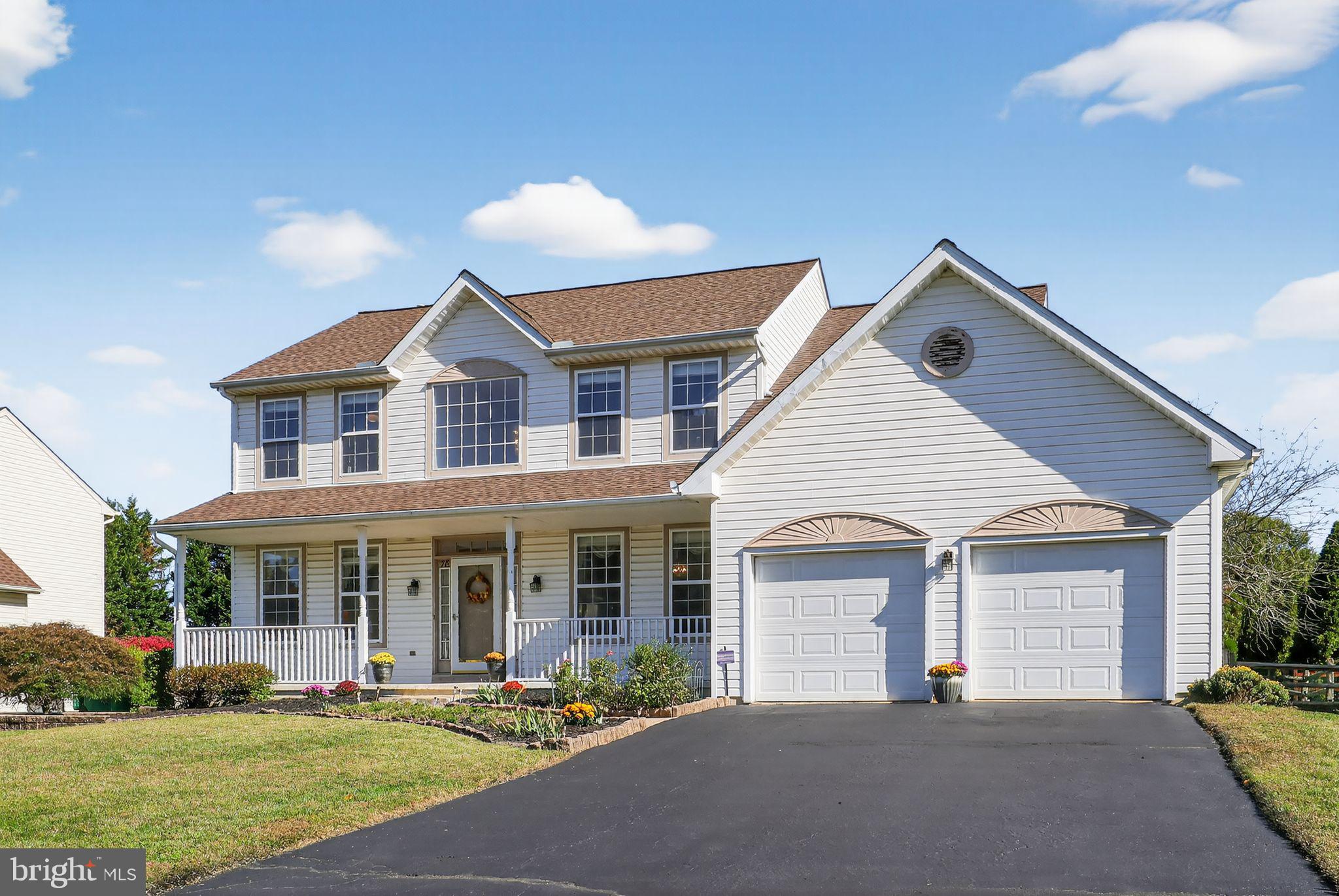 a front view of a house with a yard and potted plants