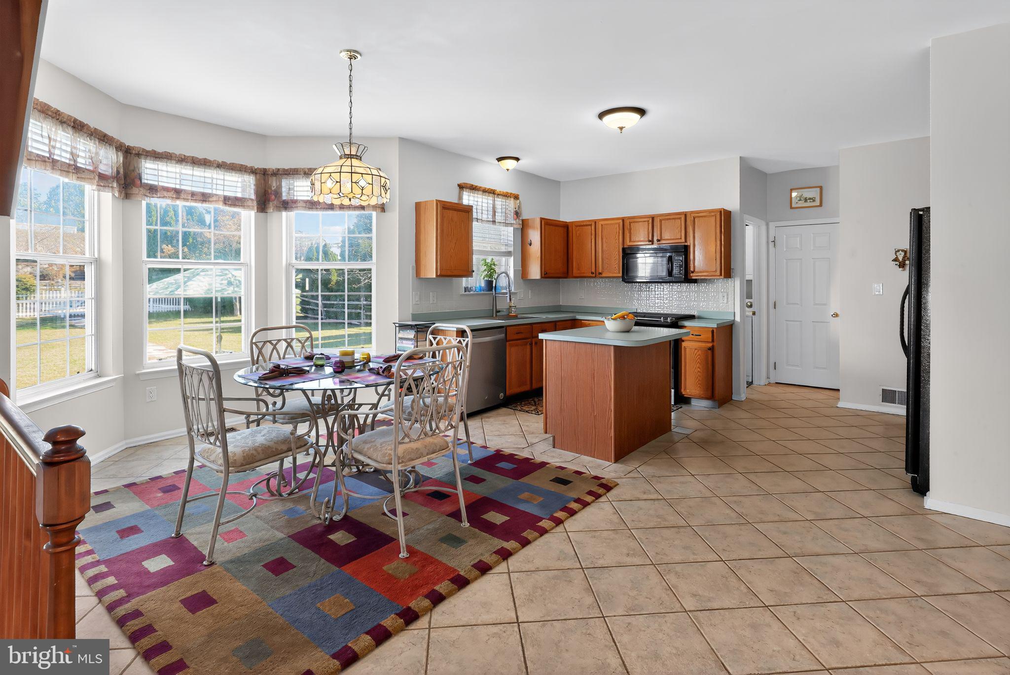 78 Emerald Ridge Drive Bear, DE 19701 - Photo 8 of 30 a open kitchen with stainless steel appliances granite countertop a stove top oven a dining table and chairs with the living room view