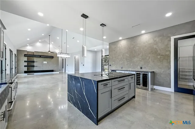 a view of an empty room with window and chandelier