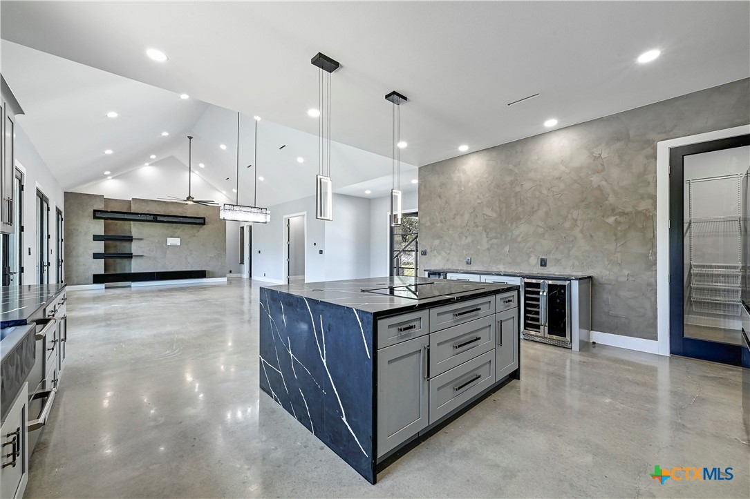 304 Spring Hollow Drive Bertram, TX 78605 - Photo 13 of 45 a large kitchen with stainless steel appliances a large counter top a stove and a sink