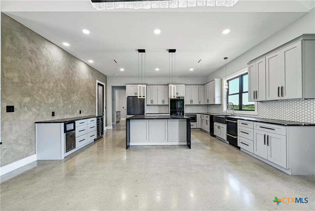 304 Spring Hollow Drive Bertram, TX 78605 - Photo 17 of 45 a large kitchen with stainless steel appliances kitchen island a large counter top and a stove