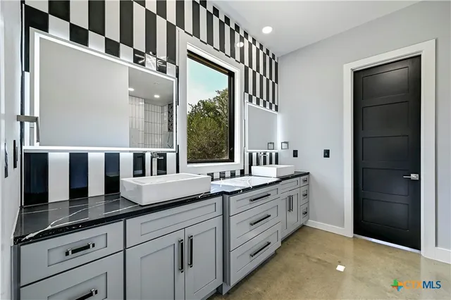 a bathroom with a sink a toilet a mirror and shower