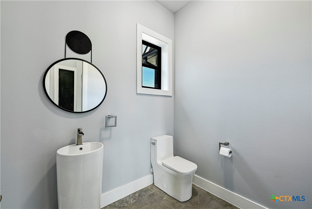 304 Spring Hollow Drive Bertram, TX 78605 - Photo 22 of 45 a bathroom with a toilet sink and mirror