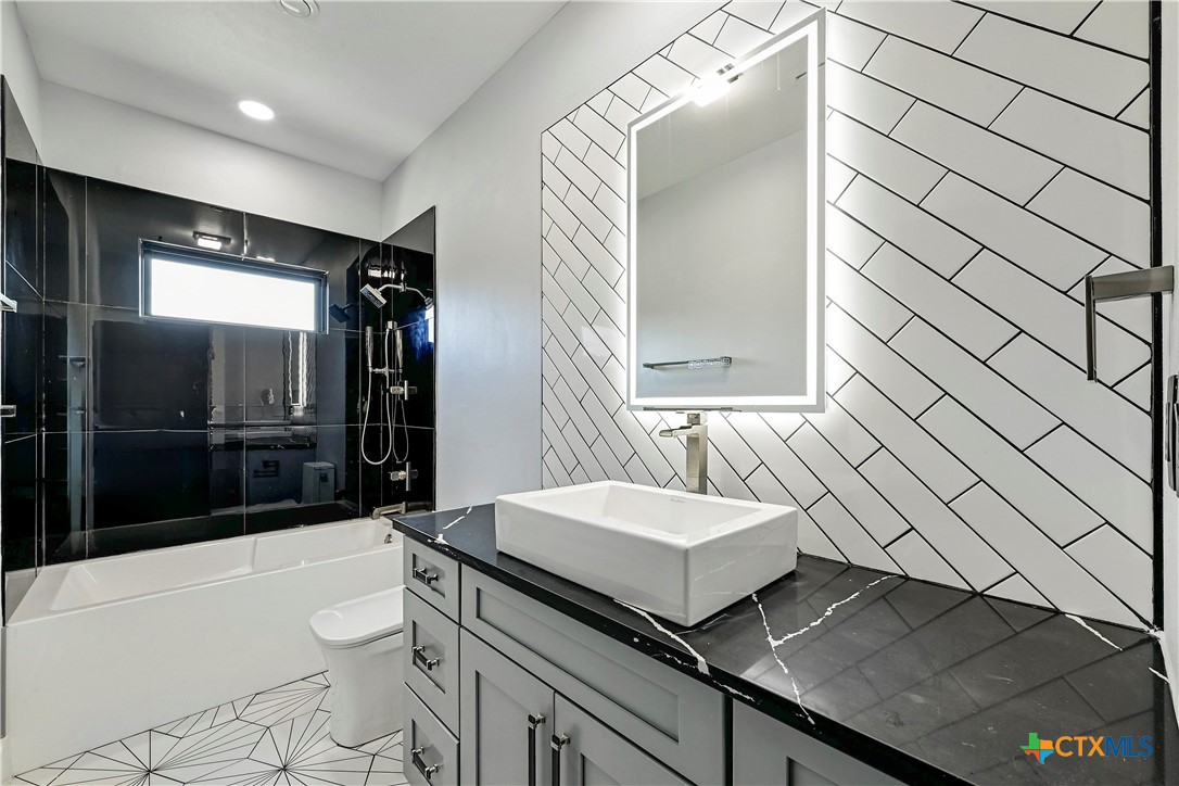 304 Spring Hollow Drive Bertram, TX 78605 - Photo 33 of 45 a bathroom with a sink a toilet and shower