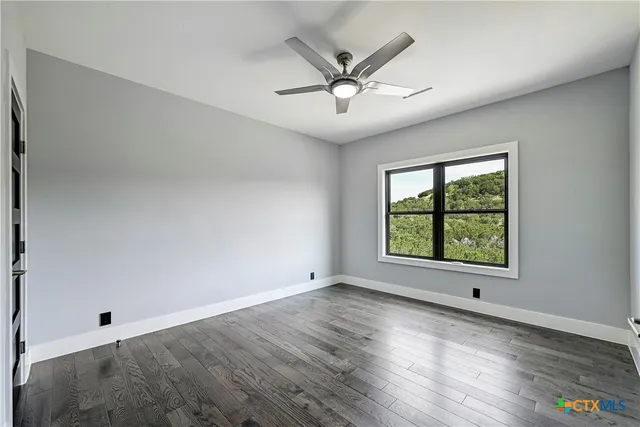 an empty room with windows and fan