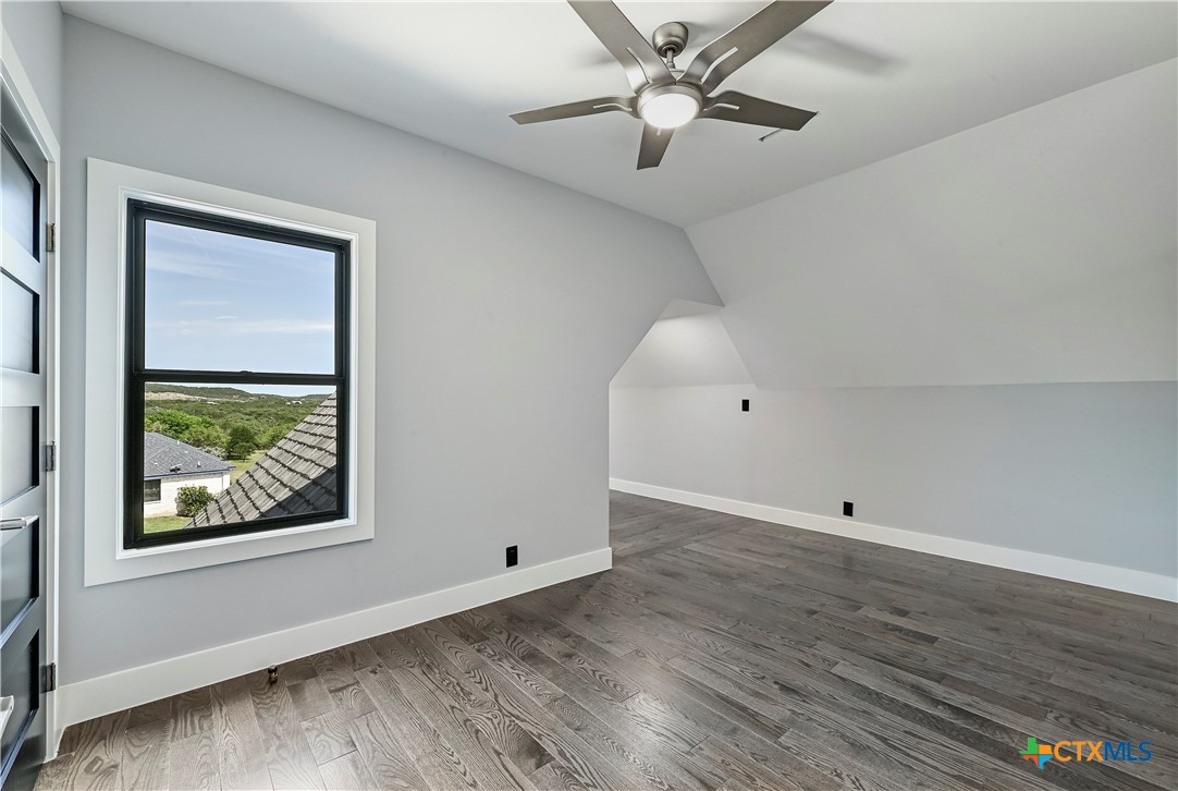 304 Spring Hollow Drive Bertram, TX 78605 - Photo 38 of 45 a view of an empty room with wooden floor and a window